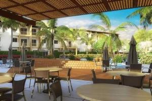 塞古罗港Resort Ondas Praia的一间设有桌椅的餐厅,种植了棕榈树
