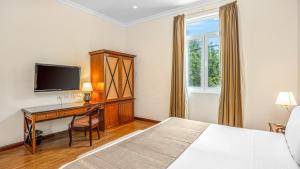 皮乌拉皮乌拉LP洛斯波塔利斯酒店的一间卧室配有一张床和一张书桌及电视
