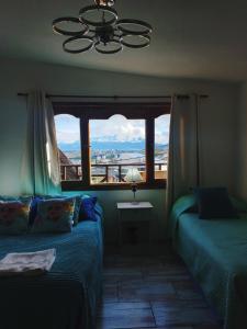 乌斯怀亚Ushuaia magnífica, cabaña 3 dormitorios的一间卧室设有两张床和一个美景窗户。