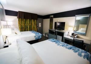 曼彻斯特Lx Hotel, Manchester, Tennessee的酒店客房,设有两张床和镜子
