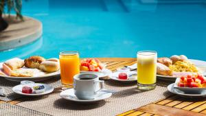皮乌拉皮乌拉LP洛斯波塔利斯酒店的一张桌子,上面放有盘子和两杯橙汁