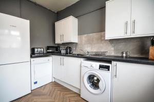 The Good night rooms liverpool的厨房配有白色橱柜、洗衣机和烘干机