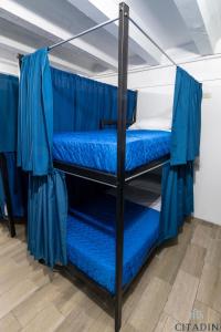 危地马拉Hotel Citadin的配有蓝色床单的客房内的两张双层床