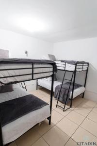 危地马拉Hotel Citadin的铺有瓷砖地板的客房配有两张双层床。