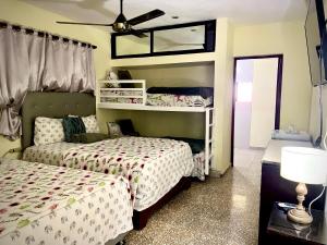 HigueyHotel Maria Bonita Higüey的一间卧室配有两张床和吊扇