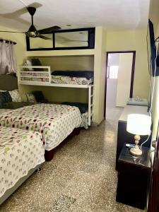 HigueyHotel Maria Bonita Higüey的一间卧室配有两张床和一张带台灯的桌子