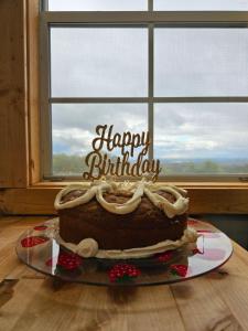 丹德里奇Chasing Views Tiny House的坐在窗前桌子上的生日蛋糕