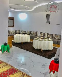 Maison d'hôte Riad Tounfite的客厅配有两张桌子和一张沙发