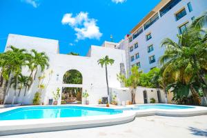 坎昆帕拉多尔酒店的棕榈树建筑前的游泳池