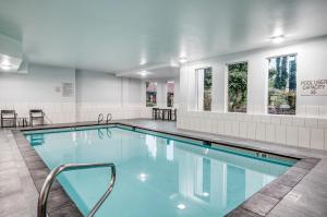 费德勒尔韦Staybridge Suites Federal Way - Seattle South , an IHG Hotel的一个带桌椅和窗户的游泳池