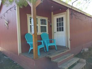 KempnerThe Butterfly Cabin with adjustable king-size bed.的两把椅子坐在一个小房子的门廊上