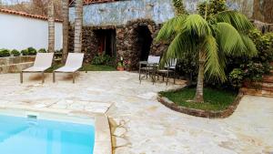 伊科德洛斯维诺斯Las Villas de Gardel的一个带桌椅和棕榈树的庭院