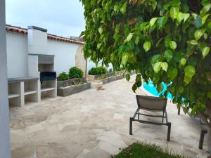 伊科德洛斯维诺斯Las Villas de Gardel的坐在树下天井上的椅子