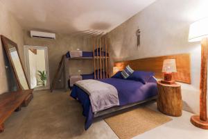 El Paredón Buena VistaKa´ana Surf的一间卧室配有一张带蓝色枕头的床