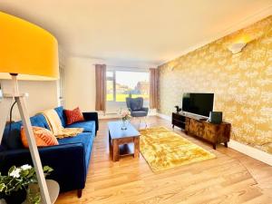 Canvey IslandCanvey Island Bliss By Artisan Stays I Free Parking I Weekly or Monthly Stay Offer I Sleeps 5的客厅配有蓝色的沙发和电视