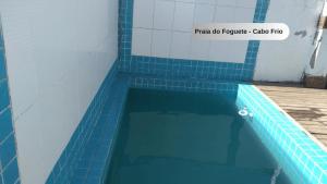 卡波布里奥Praia do Foguete - Aluguel Econômico的游泳池铺有蓝色瓷砖地板。