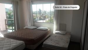 卡波布里奥Praia do Foguete - Aluguel Econômico的一间小卧室,配有两张床和窗户
