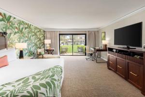 印第安维尔斯Tommy Bahama Miramonte Resort & Spa的配有一张床和一台平面电视的酒店客房