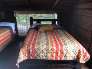 Poasito拉古尼亚斯德尔波阿斯山林小屋的小木屋内一间卧室,配有一张床