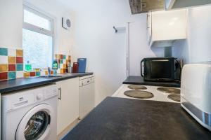 贝尔法斯特House Close to City Centre and City Airport的厨房配有洗衣机和微波炉。