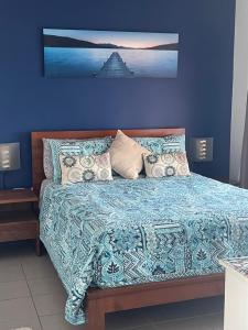 LarrakeyahMarina Views Apartment Cullen Bay的一间卧室配有一张蓝色墙壁的床