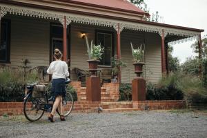 亚历山德拉Summerlands - Country Luxe的一位妇女骑着自行车在房子前面行走