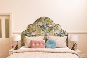 亚历山德拉Summerlands - Country Luxe的一间卧室配有一张大床和花卉床头板