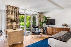 奥克兰Gorgeous Herne Bay Pied Terre - Auckland Central的一间卧室配有一张床、一张桌子和一把椅子