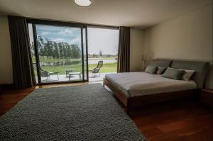 何塞伊格纳西奥Estancia Santa Cruz的一间卧室设有一张床和一个带庭院的大窗户