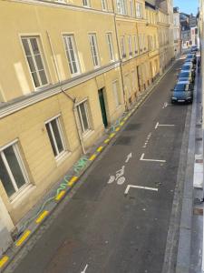 鲁昂Le Saint-André, Gare de Rouen的一条空的街道,汽车停在大楼的一侧