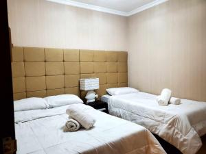 碧瑶Kaias Transient & Condotels - 539 Albergo的一间设有两张床铺和毛巾的房间