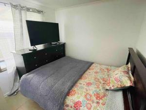 圣地亚哥Casa Aislada Peñaflor-Malloco的一间卧室配有一张带梳妆台和电视的床。
