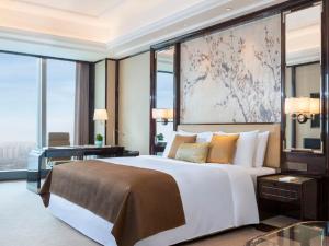 长沙长沙瑞吉酒店的一间卧室配有一张大床、一张书桌和窗户。