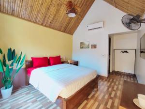 河江Ha Giang Wings Bungalow的一间卧室配有一张带红色枕头的大床