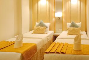 美岸UrbanView @ Stay Inn Style Hotel Vigan的酒店客房,配有两张带毛巾的床