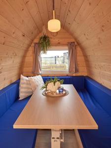 温讷鲁普Boathouses - Overnat på vandet ved Limfjorden的一张蓝色沙发的木桌