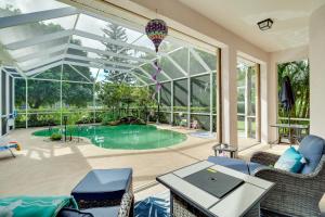 Merritt IslandRanch-Style Florida Retreat with Pool and Lanai的一个带游泳池和大窗户的庭院