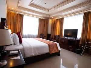 日惹The Rich Jogja Hotel的酒店客房,配有床和电视