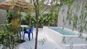 Ban Nong Hinบ้านเซฟโซน的游泳池旁的天井设有桌子和树