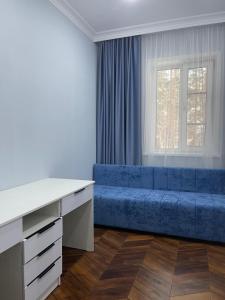 博罗沃耶SULTAN PLAZA Borovoe的客厅,窗户前设有蓝色沙发