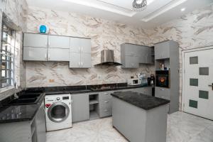 莱基Luxury 4 bedroom duplex的厨房配有白色橱柜、洗衣机和烘干机