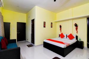 布巴内什瓦尔OYO Flagship Sri Balaji Guest House的一间卧室配有一张床和一个沙发