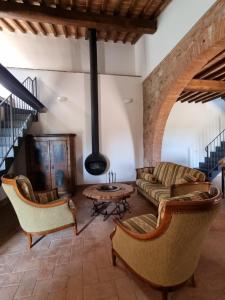 阿巴迪蒙提帕克Fornace del Conte的客厅配有沙发、椅子和桌子