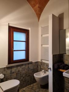 阿巴迪蒙提帕克Fornace del Conte的一间带水槽和卫生间的浴室以及窗户。