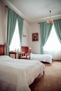 OstromeckoZespół Pałacowo-Parkowy w Ostromecku的一间卧室配有两张带蓝色窗帘的床和一张桌子