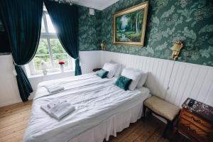 瑟尔沃斯堡Mjällbyhus Pensionat & Stugby的卧室配有一张白色大床和绿色壁纸