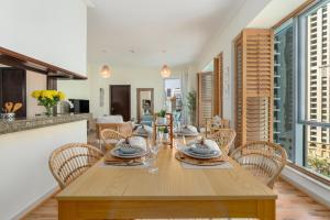 迪拜Boutique Apartment Sea Views - Dubai Marina的一间带木桌和椅子的用餐室