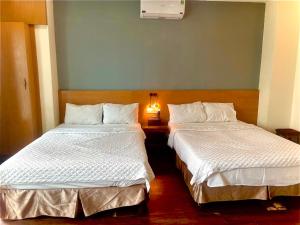 河内THỦY TÚ HOTEL的两张睡床彼此相邻,位于一个房间里