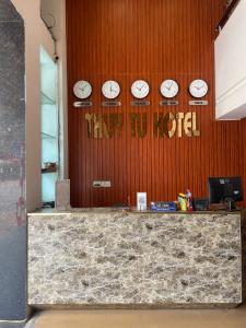 河内THỦY TÚ HOTEL的墙上有四个钟的柜台