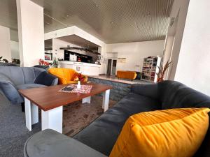 卢切内茨Hotel Pelikán的带沙发和桌子的客厅以及厨房。